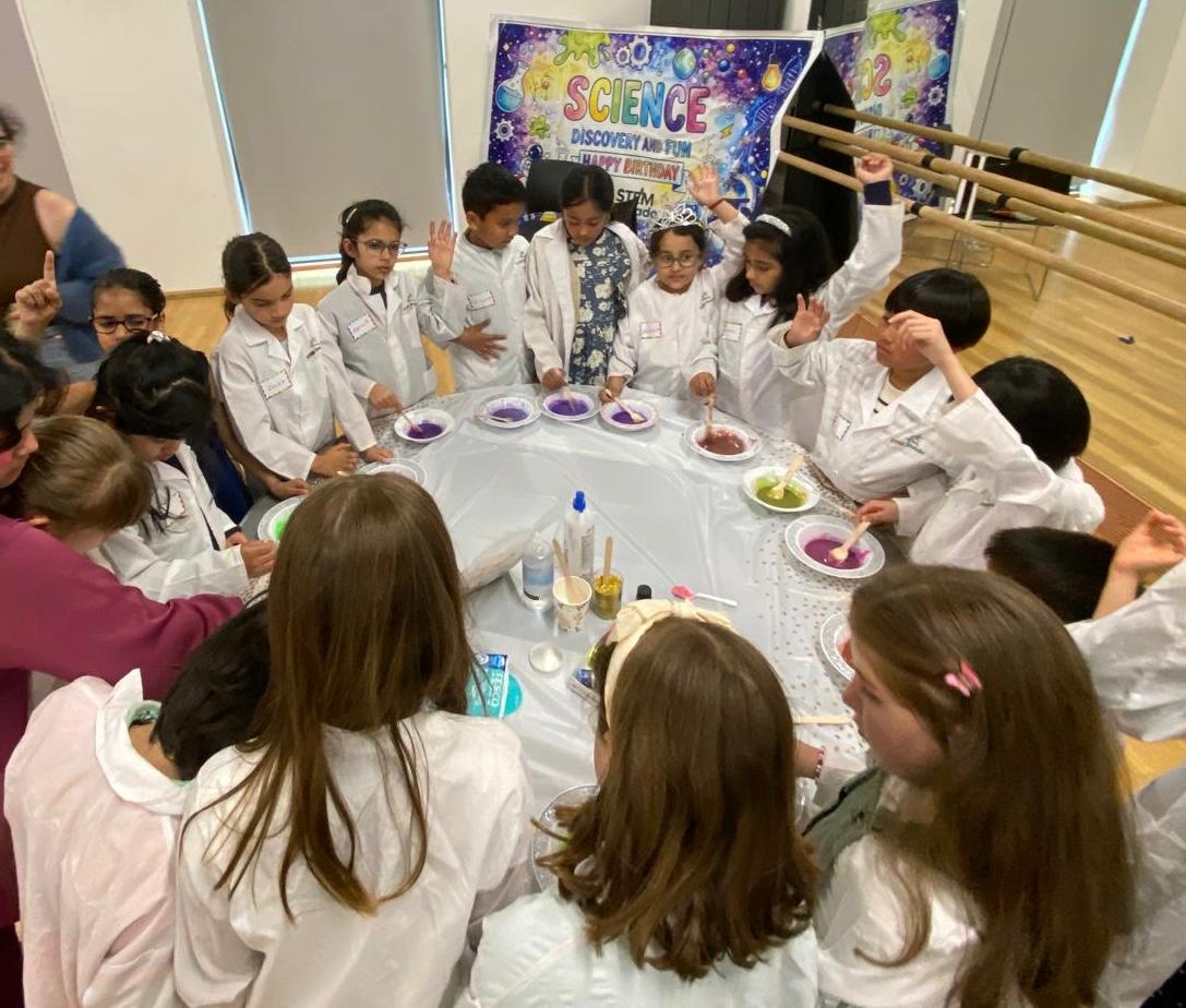 Children in lab coats celebrating at a science birthday party